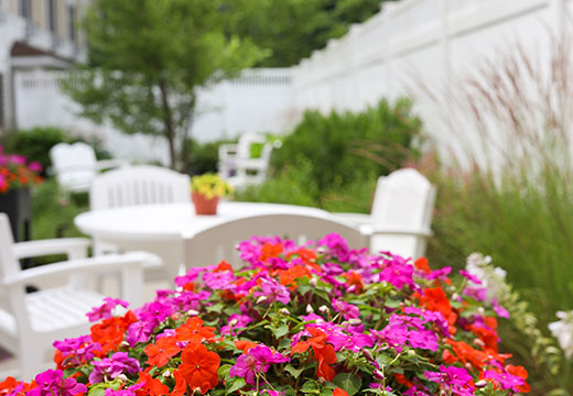 Assisted living garden with tables and chairs.