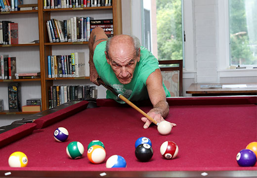 Older man playing billards.